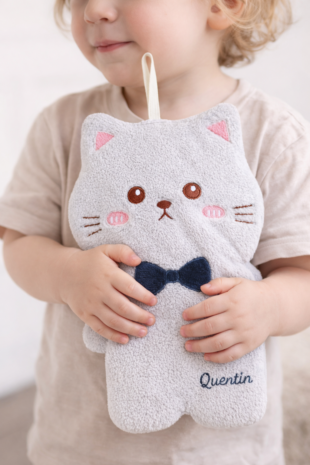 Bébé tenant un doudou chat gris personnalisé avec prénom brodé, doux et adapté dès la naissance, idéal comme cadeau bébé