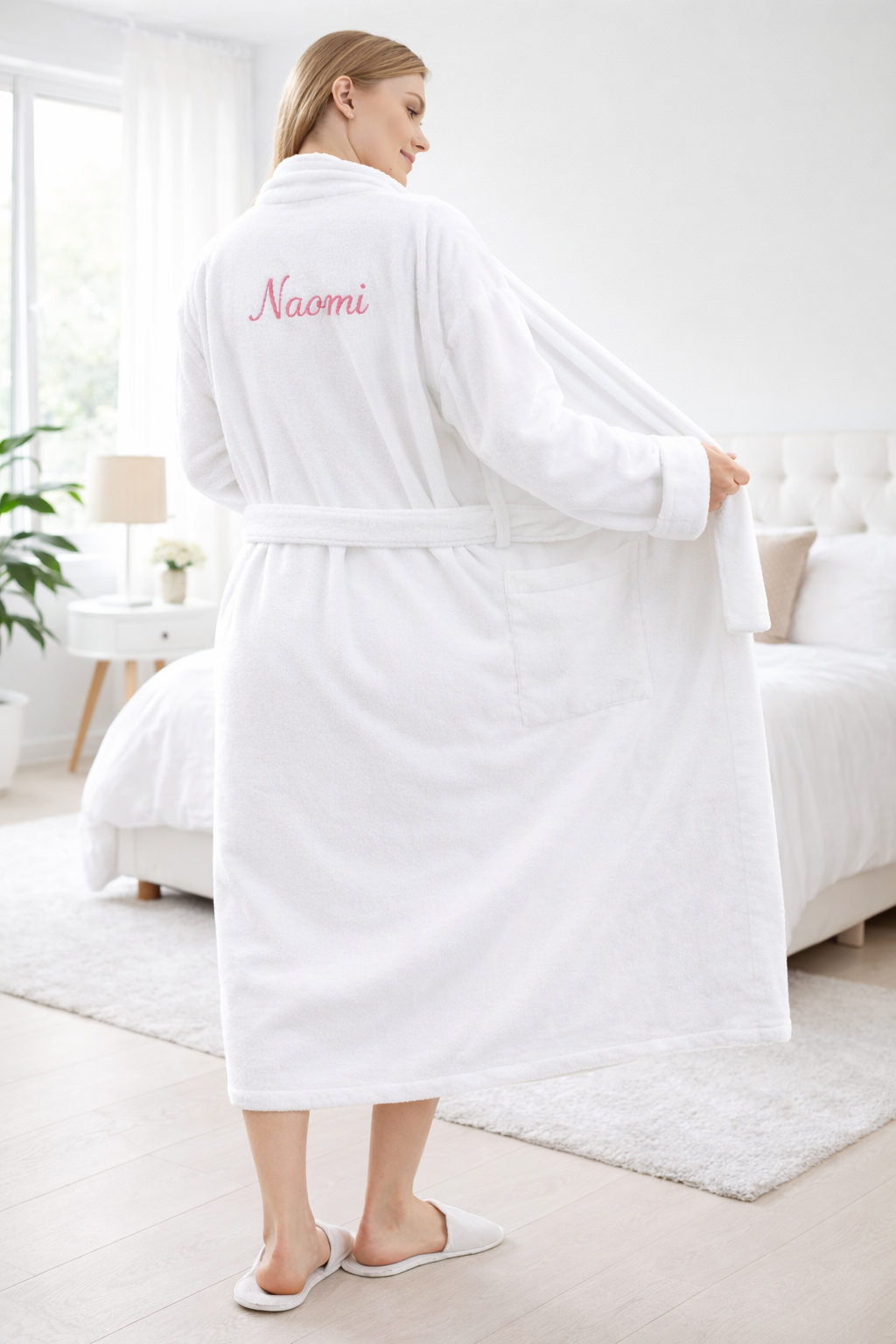 Femme portant un peignoir blanc en coton avec prénom Naomi brodé dans le dos, peignoir personnalisé confortable et élégant pour la maison