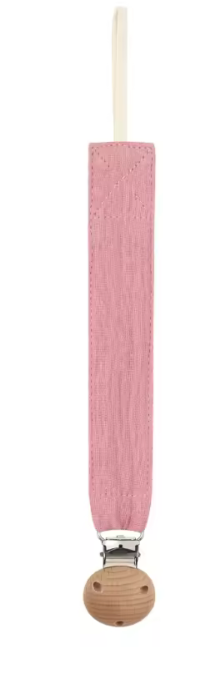 Attache-sucette en tissu rose, de forme longue et étroite, avec une boucle en haut et un clip métallique fixé sur une pièce ronde en bois.