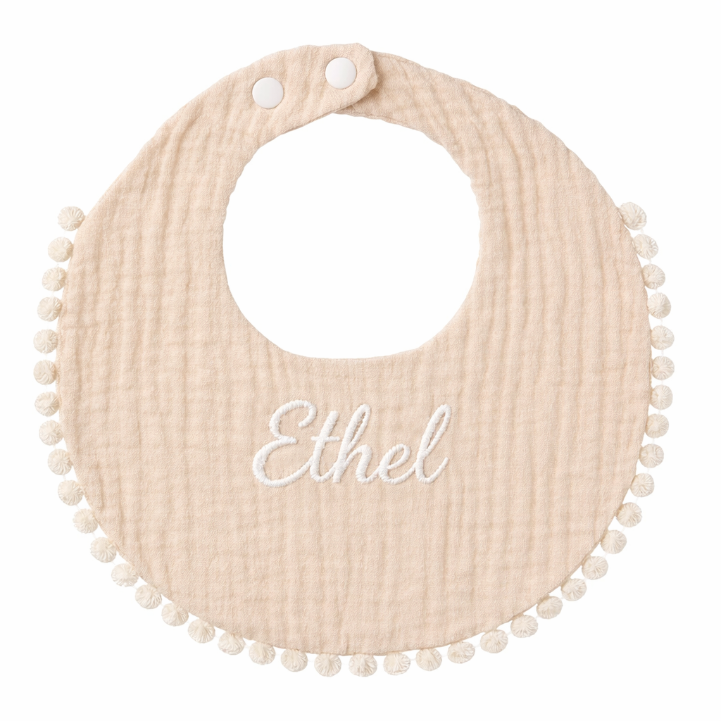 Bavoir bébé rond beige en gaze de coton avec bordure pompons et fermeture à pressions Broderie prénom 
