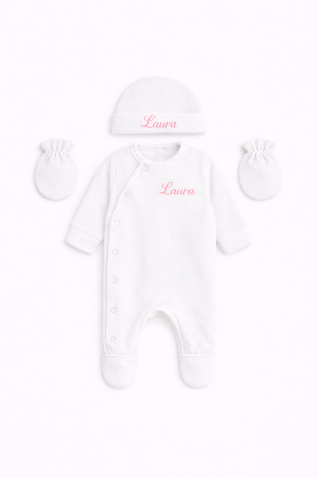 Combinaison pour bébé avec fermeture latérale, présentée avec un bonnet et deux moufles assortis. broderie