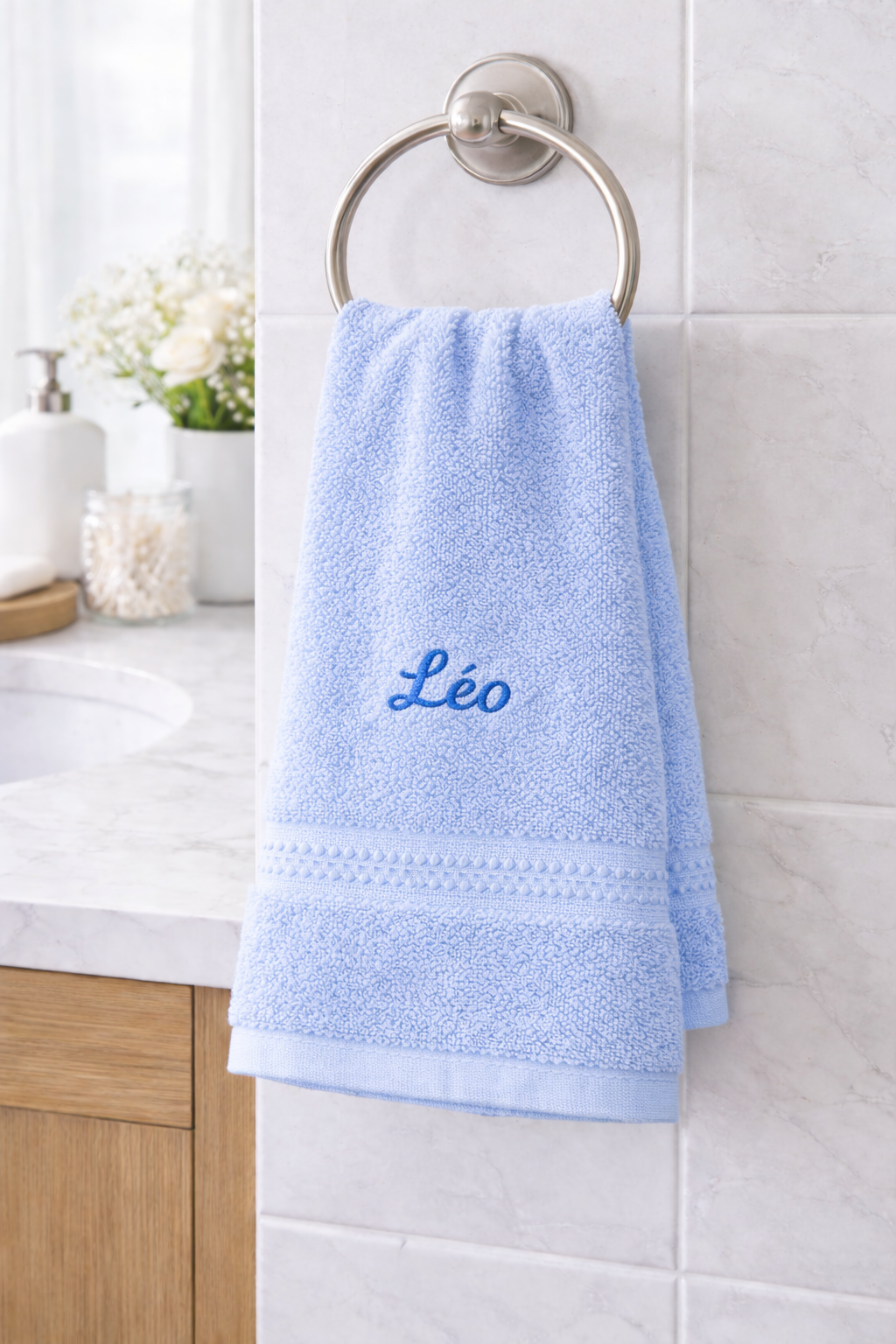 Serviette de toilette personnalisée avec broderie prénom accrochée dans salle de bain
