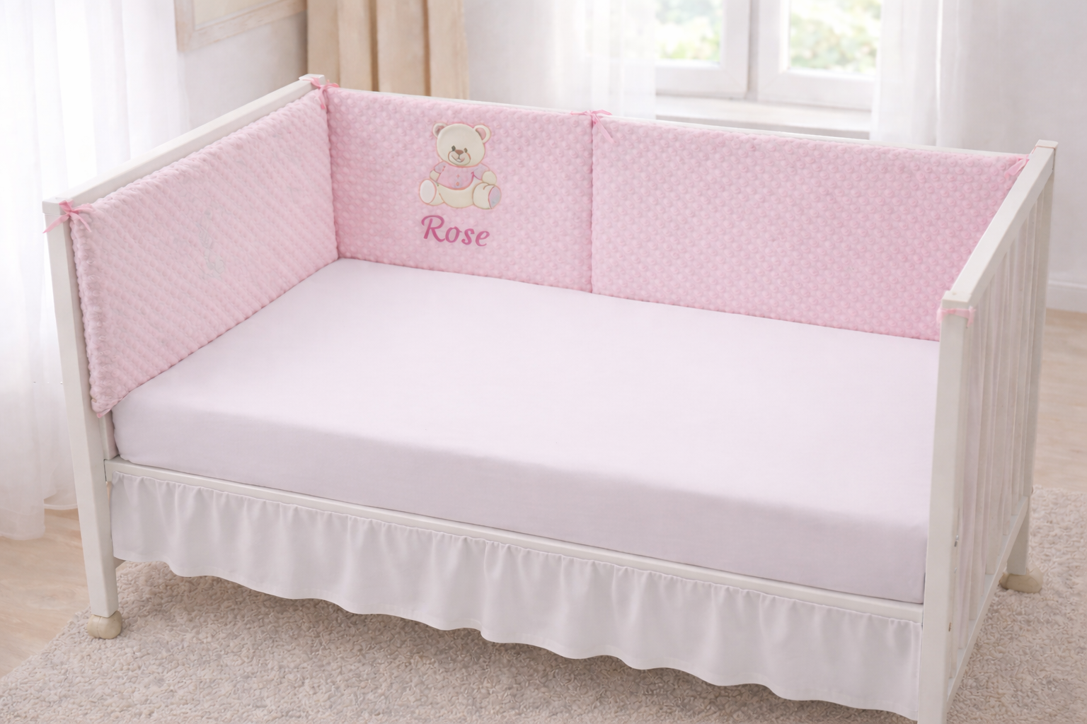 Tour de lit bébé  personnalisé avec prénom brodé , en tissu doux  pilou pilou, installé dans un lit bébé blanc dans une chambre 