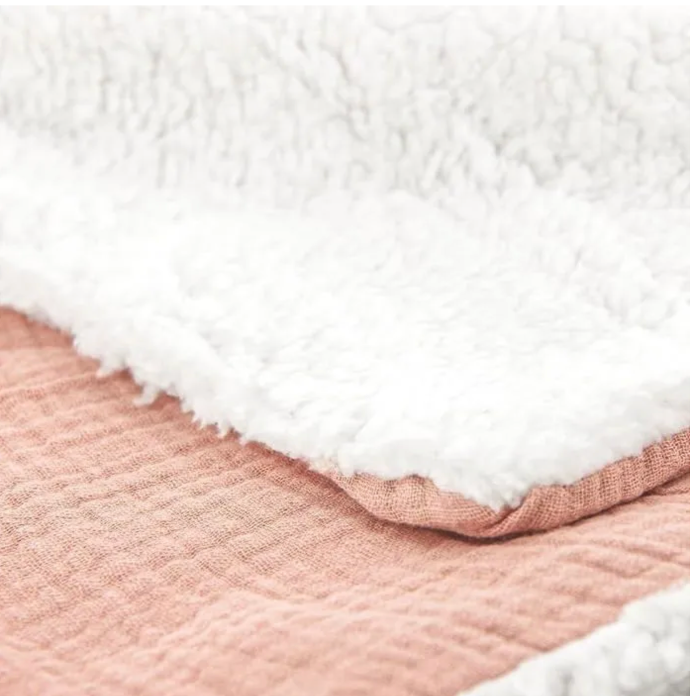 couverture bébé blanche pliée avec matière douce et chaude rose