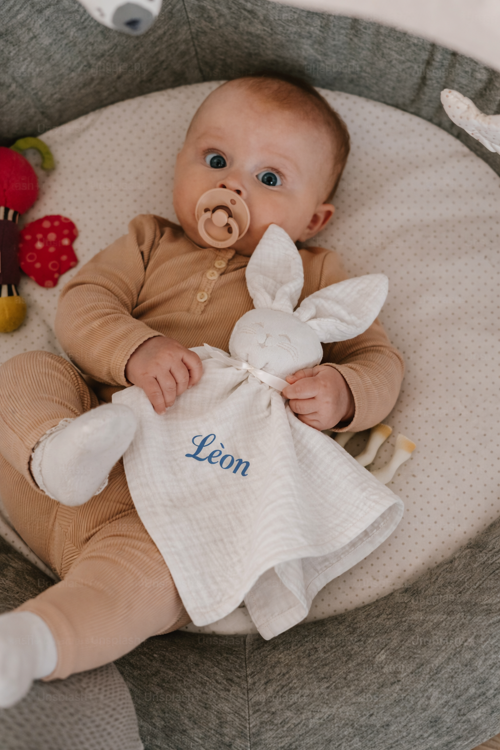 mise en scene doudou bébé blanc  en coton avec tête lapin et lange souple