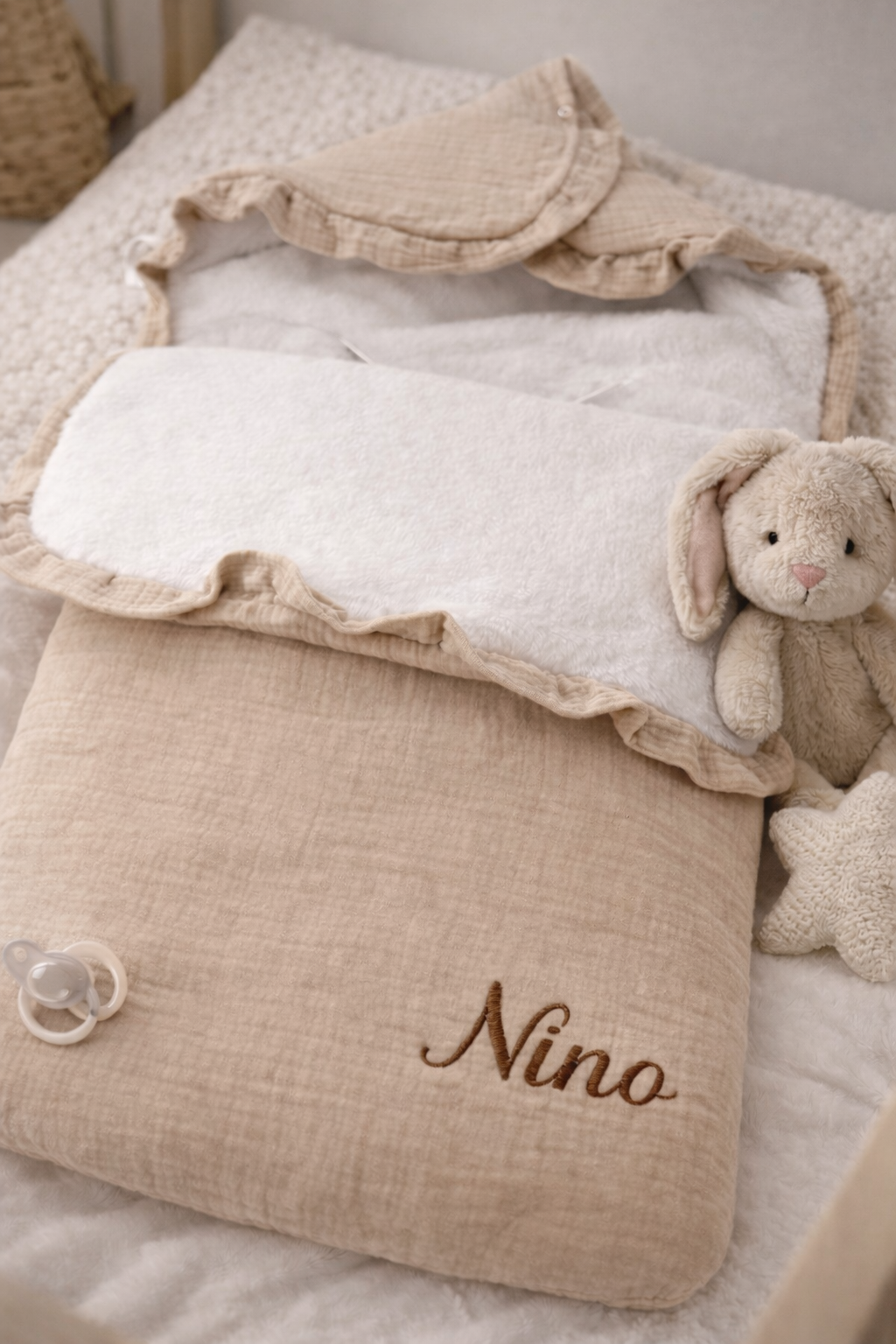 nid d’ange bébé beige en coton avec doublure moelleuse et confortable sur lit 