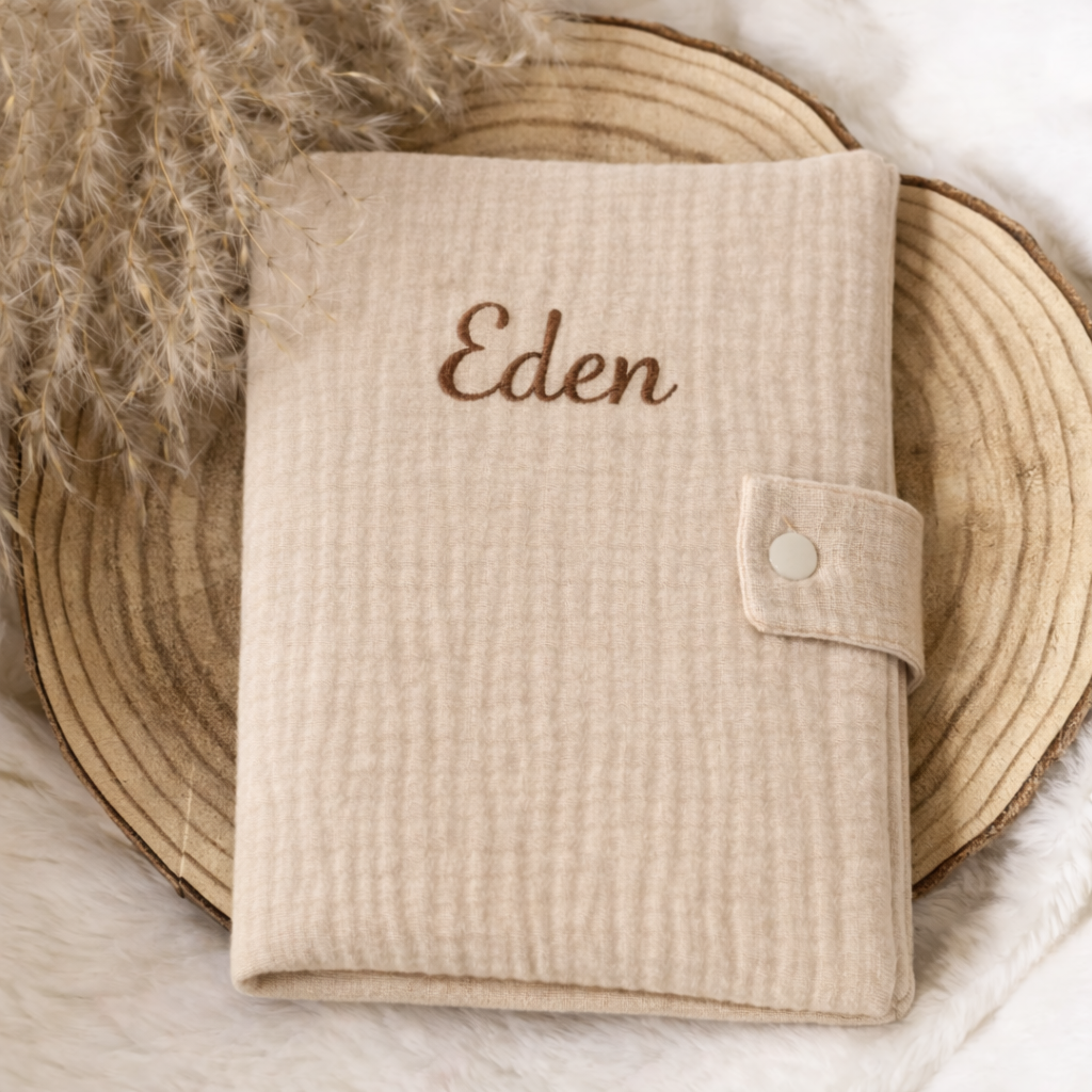 protège carnet de santé bébé en tissu doux posé avec accessoires naissance et doudou beige 